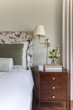 a bedroom with a bed, nightstand and lamp