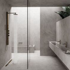 a bathroom with two sinks and a shower in the middle of it, surrounded by concrete walls