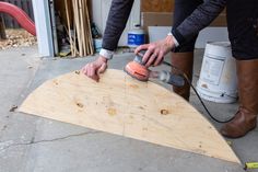 a man sanding up a piece of plywood