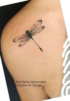 a small dragonfly tattoo on the shoulder