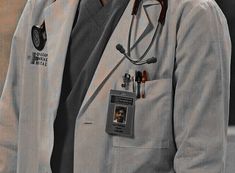 a man in a gray suit with a stethoscope on his chest and name tag