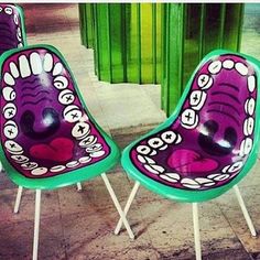 two purple chairs sitting next to each other on top of a tile floor in front of a green building