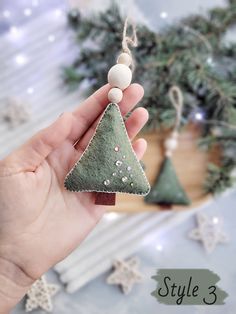 a hand holding a small christmas tree ornament