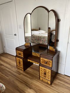 a bedroom with a bed, dresser and mirror in it's corner on the floor