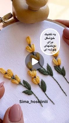 someone is stitching flowers on a piece of fabric