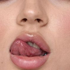 a close up of a woman's lips with her tongue sticking out to the side