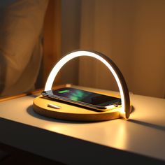 a cell phone sitting on top of a wooden table next to a white light fixture