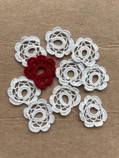 red and white crochet flowers sitting on top of a cardboard box