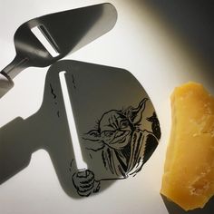 a star wars yoda cutting board next to a cheese grater and slicer