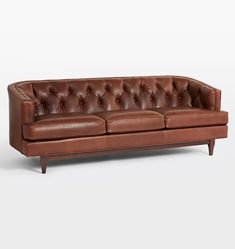 a brown leather couch sitting on top of a white floor