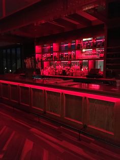 a dimly lit bar with red lights in the background