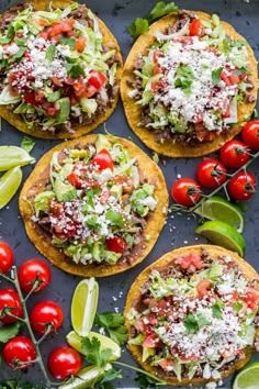 four tortillas topped with shredded cheese, tomatoes and avocado on a baking sheet