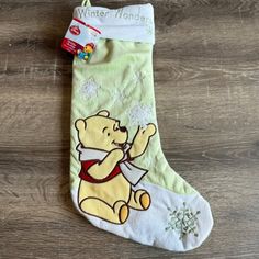 a winnie the pooh christmas stocking hanging on a wooden floor