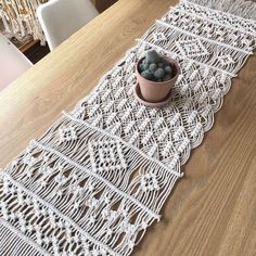 a potted plant sitting on top of a table next to a white crochet runner