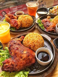 a table topped with plates filled with different types of food next to cups and sauces