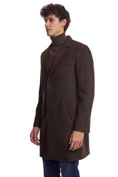 The Chocolate Brown Notch Topcoat is a timeless addition to any wardrobe. Crafted from a poly-wool blend, it features a classic notch collar, faux hair texture, and front pockets for practicality. Its rich chocolate hue and tailored fit make it appropriate for both formal and casual settings. This ensures you stay warm and stylish throughout the colder months.PRODUCT DETAILS: style 6491C slim-fitting long sleeve notch collar faux hair texture poly-wool blend dry clean only imported Brown Business Outerwear With Concealed Placket, Classic Brown Wool Coat With Button Closure, Brown Wool Coat With Lapel Collar And Concealed Placket, Classic Single-breasted Brown Wool Coat, Business Brown Wool Coat With Concealed Placket, Brown Wool Coat With Pockets For Business, Brown Wool Coat With Hidden Button Closure For Business, Classic Brown Wool Coat For Business, Tailored Brown Wool Coat With Concealed Placket