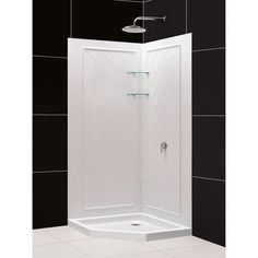 a white shower stall in a black and white tiled bathroom