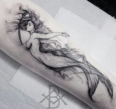 a woman's leg with a long flowing hair tattoo design on the right thigh