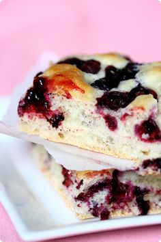 two blueberry scones are stacked on top of each other, with one being held by a plastic spoon