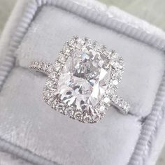 a cushion cut diamond engagement ring in a velvet box with the band around it's edges