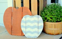 two wooden heart shaped planters sitting next to each other on the front step of a house