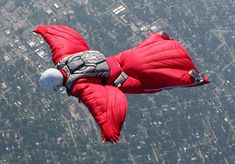 a man is in the air while parachuting with a parachute over a city