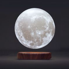 a large white moon sitting on top of a wooden stand