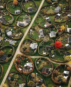 an aerial view of houses and roads in the countryside with trees, shrubs and grass