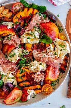 a white bowl filled with lots of different types of food on top of a table