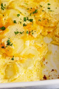 an omelet with potatoes and parsley in a white casserole dish