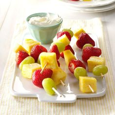 fruit skewers are arranged on a white plate