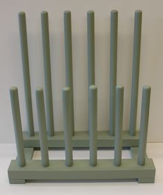 a green shelf with four candles on it and several poles sticking out of the top