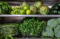 fresh vegetables are displayed on shelves in a store