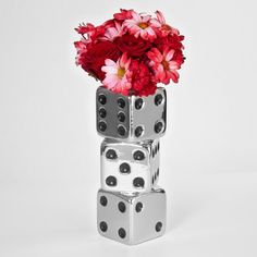 three dices stacked on top of each other with flowers in the middle and one is filled with pink daisies