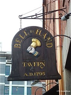 a sign hanging from the side of a building that says bell and hand tavern ad 1971