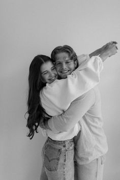 black and white photograph of two women hugging each other with their arms around one another