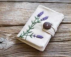 a small book with buttons on it sitting on top of a wooden table next to a button