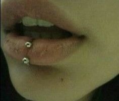 a woman with two piercings on her lip