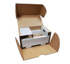 an open cardboard box with two white boxes in it