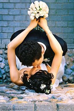 a man and woman are holding each other in the air with flowers on their heads