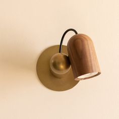 a light that is on the side of a wall with a wooden shade and black cord