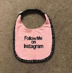 a pink bib that says follow me on instagramm with black letters in it