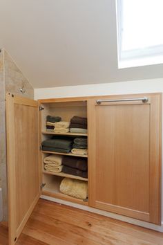 an open closet in the corner of a bathroom