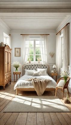 a bedroom with white walls and wood flooring has a large bed in the center