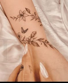 a woman's arm with flowers and butterflies on it