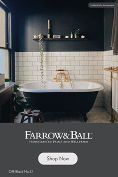 a bathroom with black and white tile, gold faucet, and an old fashioned bathtub