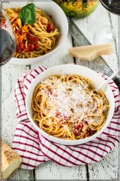 two bowls of pasta with cheese and tomato sauce