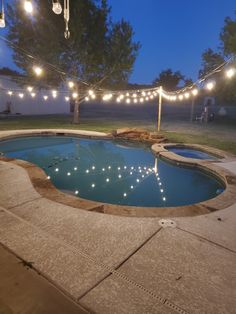 an outdoor swimming pool surrounded by string lights