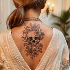 a woman with a skull and flowers tattoo on her upper back neck, wearing a white shirt