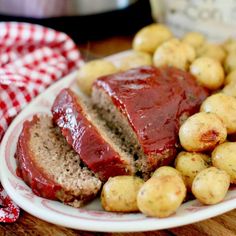 meatloaf and potatoes on a plate with a red checkered cloth next to it